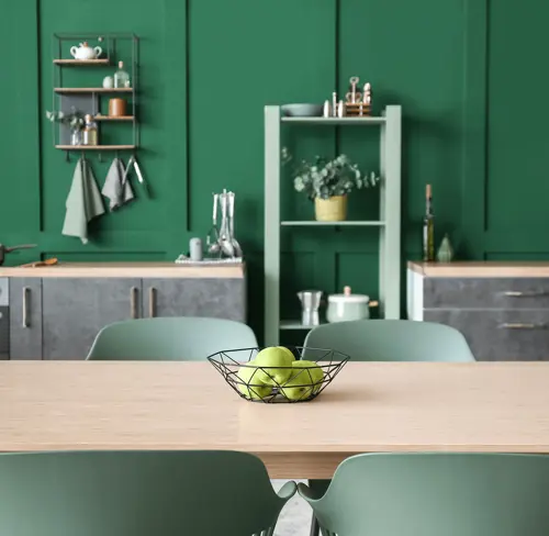 Изумрудная кухня с акцентными стульями.