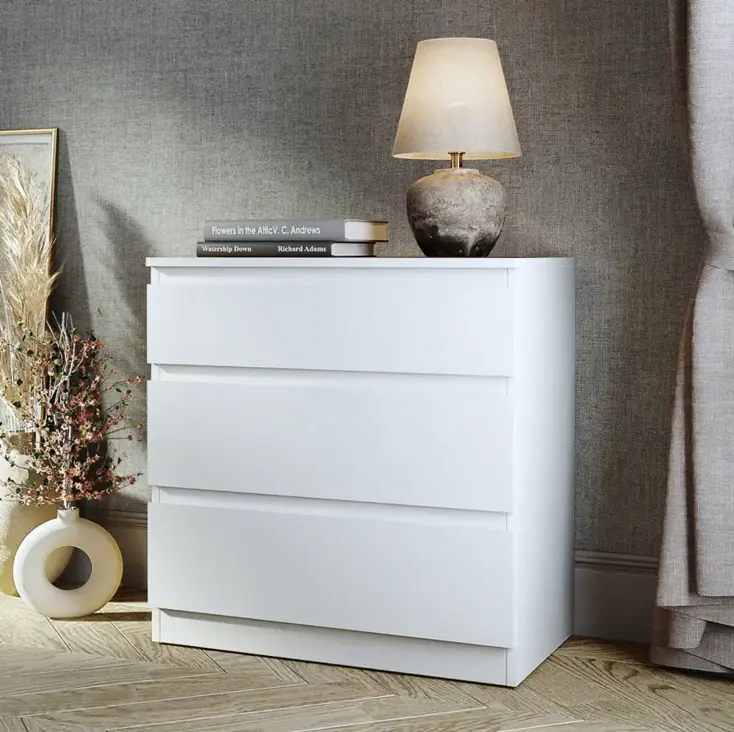 Белый комод с лампой.
