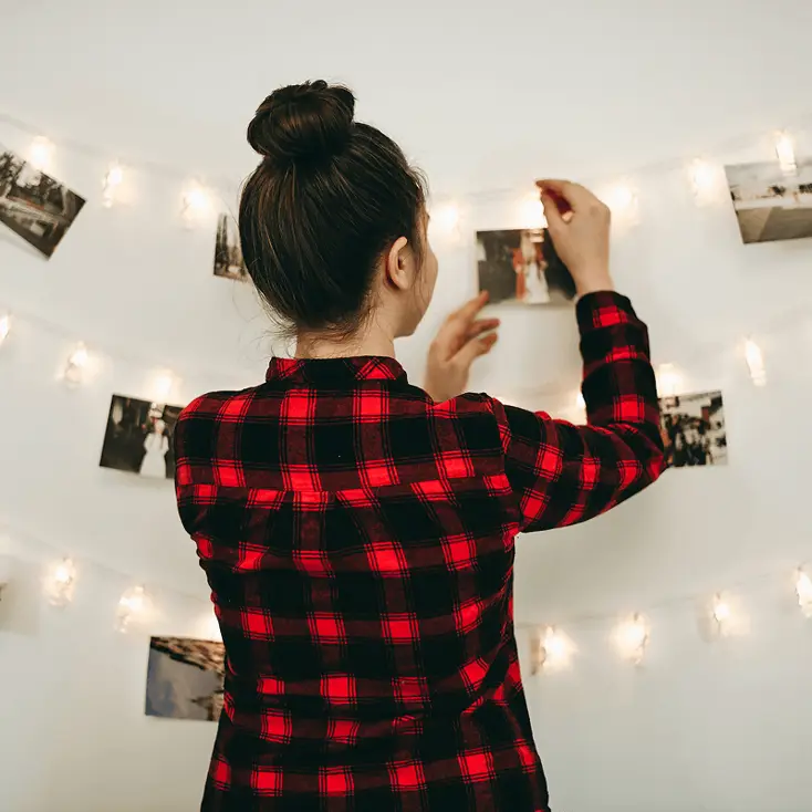 Фотографии и гирлянды на стене.