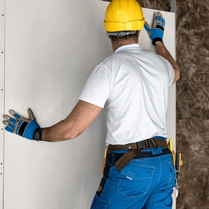 Рабочий крепит панель.